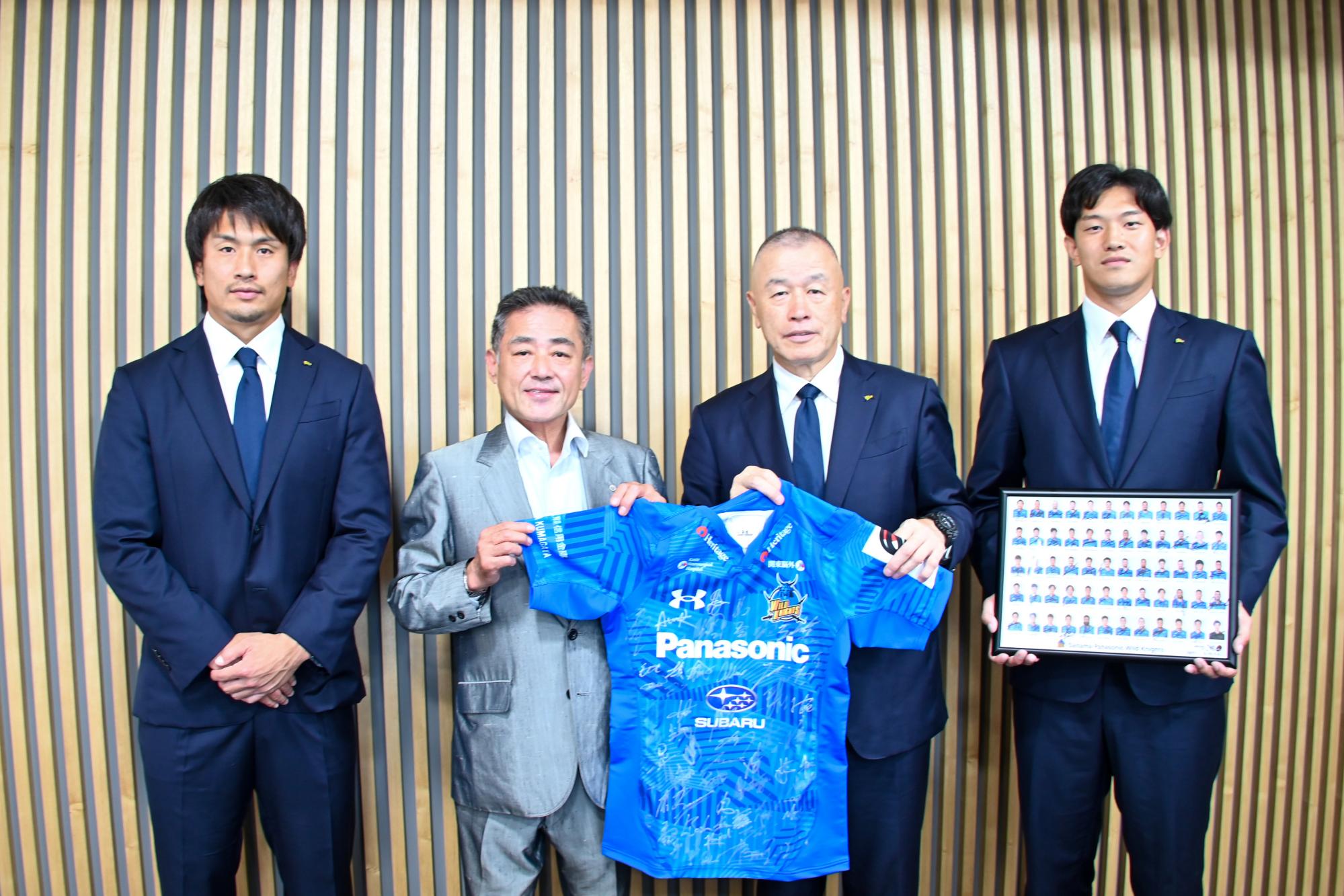 ユニフォームを手にする村山町長と表敬訪問された埼玉パナソニックワイルドナイツの選手の皆さん