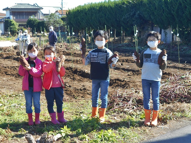 さつまいもを持つ子どもたち